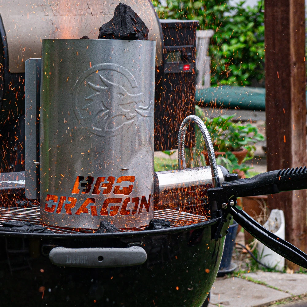 A BBQ Dragon product in use on a charcoal grill, with sparks flying around the metal device.
